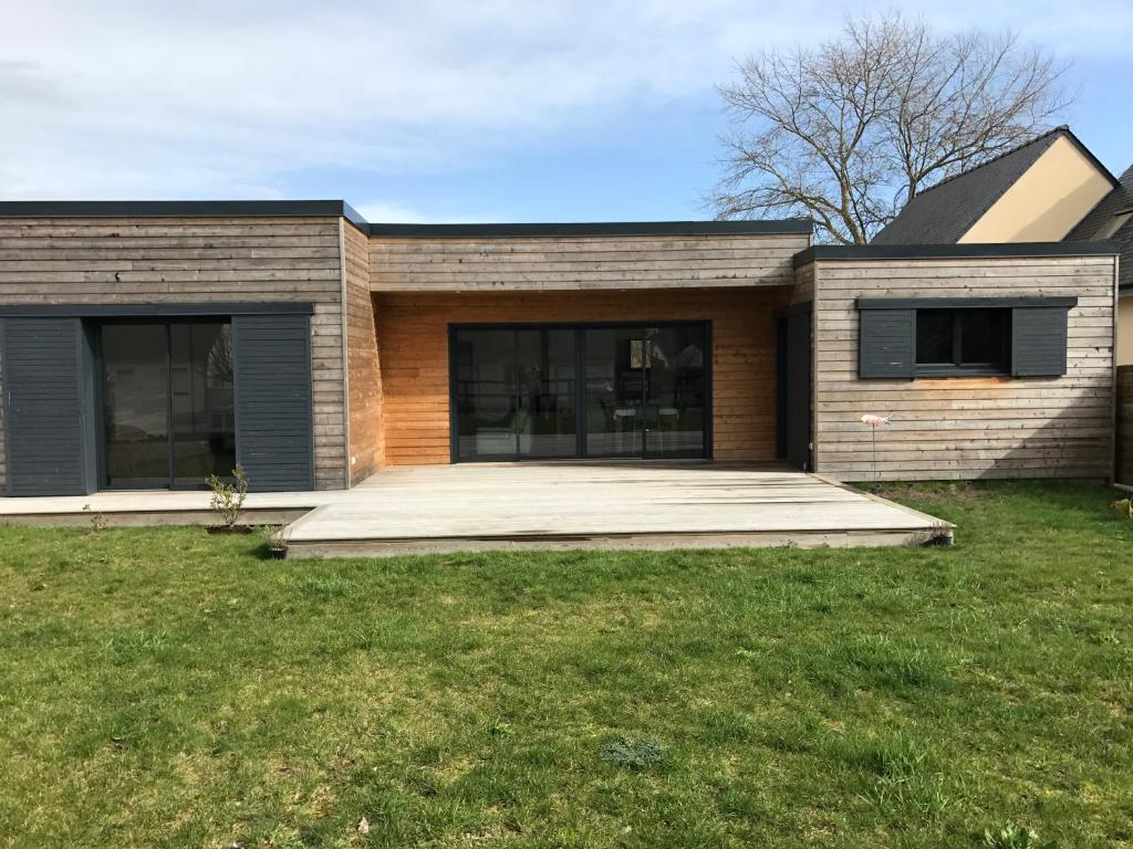 une maison en briques avec une grande pelouse devant elle dans l'établissement Loregate, à Jullouville