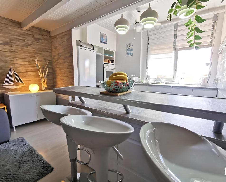 une cuisine avec un comptoir avec quatre chaises et une table dans l'établissement Le cocon bleu du cap, au Cap d'Agde