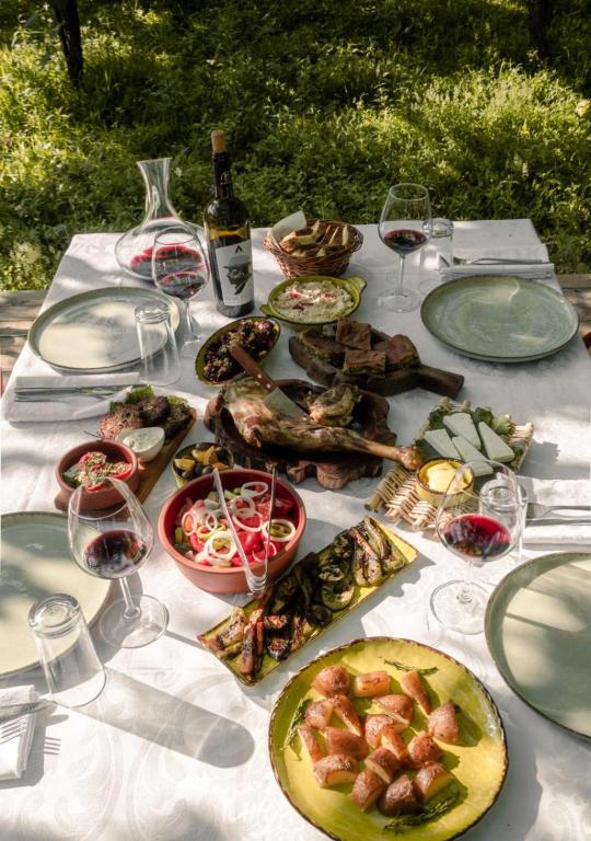 a table with plates of food and glasses of wine at Alpeta Agrotourism & Winery - Roshnik , Berat in Berat