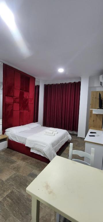 a bedroom with a bed and a table in it at Hotel kleo Airport tirana in Tirana