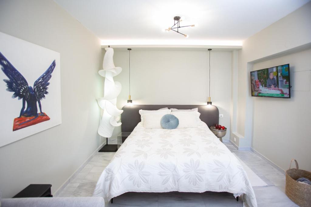 a bedroom with a white bed with white sheets at Liberty Suites II in Heraklio