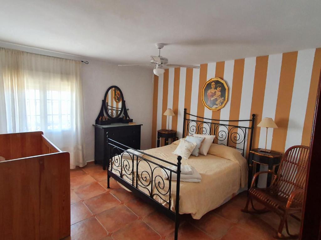 a bedroom with a bed and a mirror and a chair at Villa La Luna CHALET COMPLETO in Guadajira