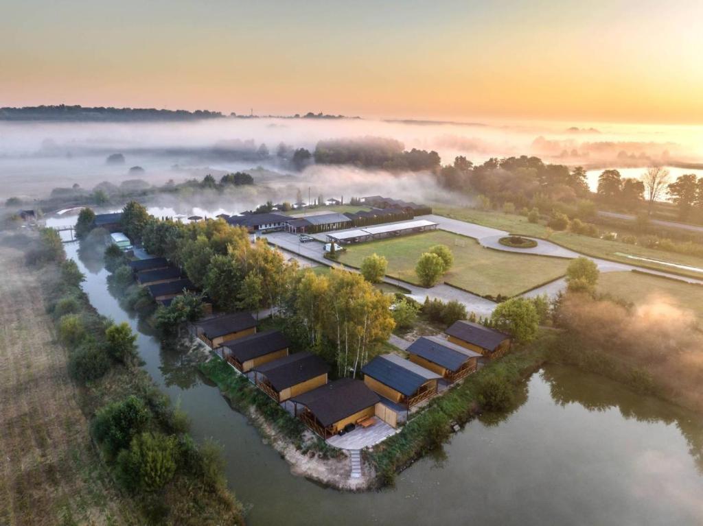 eine Luftansicht eines Bauernhofs inmitten eines Flusses in der Unterkunft Łejkówka in Wólka Magierowa
