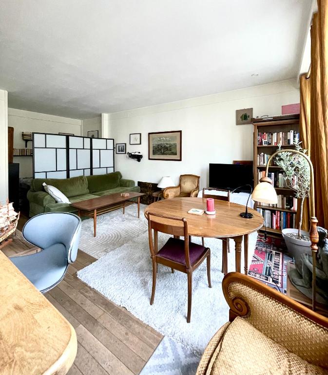 un salon rempli de meubles et d'une table dans l'établissement Studio cosy avec balcon Paris 16ème, à Paris