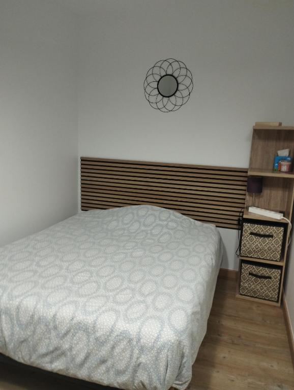 une chambre avec un lit et une horloge au mur dans l'établissement La room, à Joué-lès-Tours