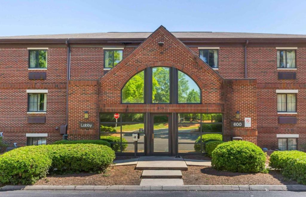 un edificio de ladrillo con un arco delante de él en Suburban Studios-Cary, en Cary