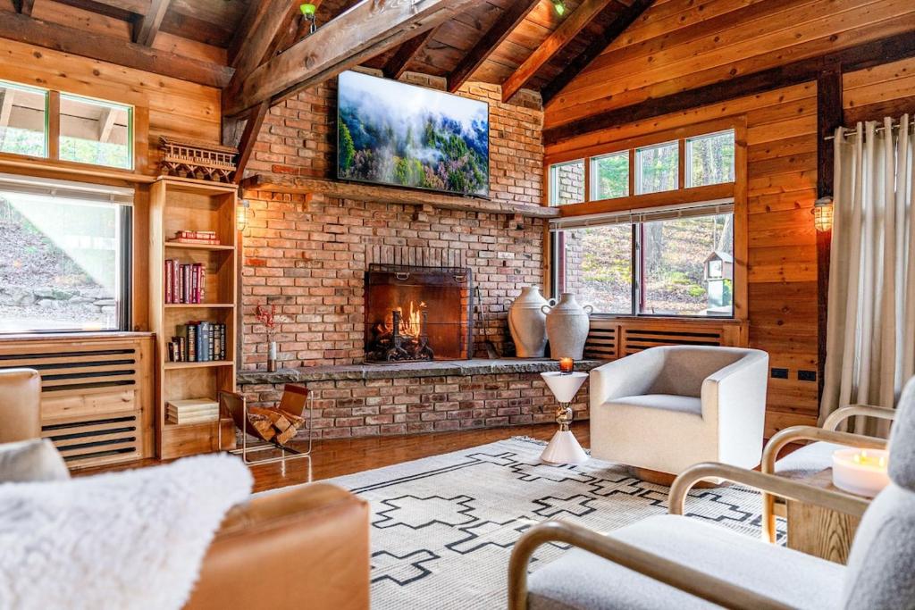 米尔福德Couple's Retreat Lodge with Hot Tub and River Views的带壁炉和电视的客厅