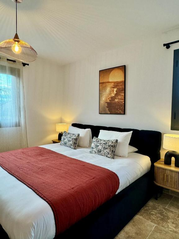 une chambre avec un grand lit avec une couverture rouge dans l'établissement Appartement Stella, à Monticello