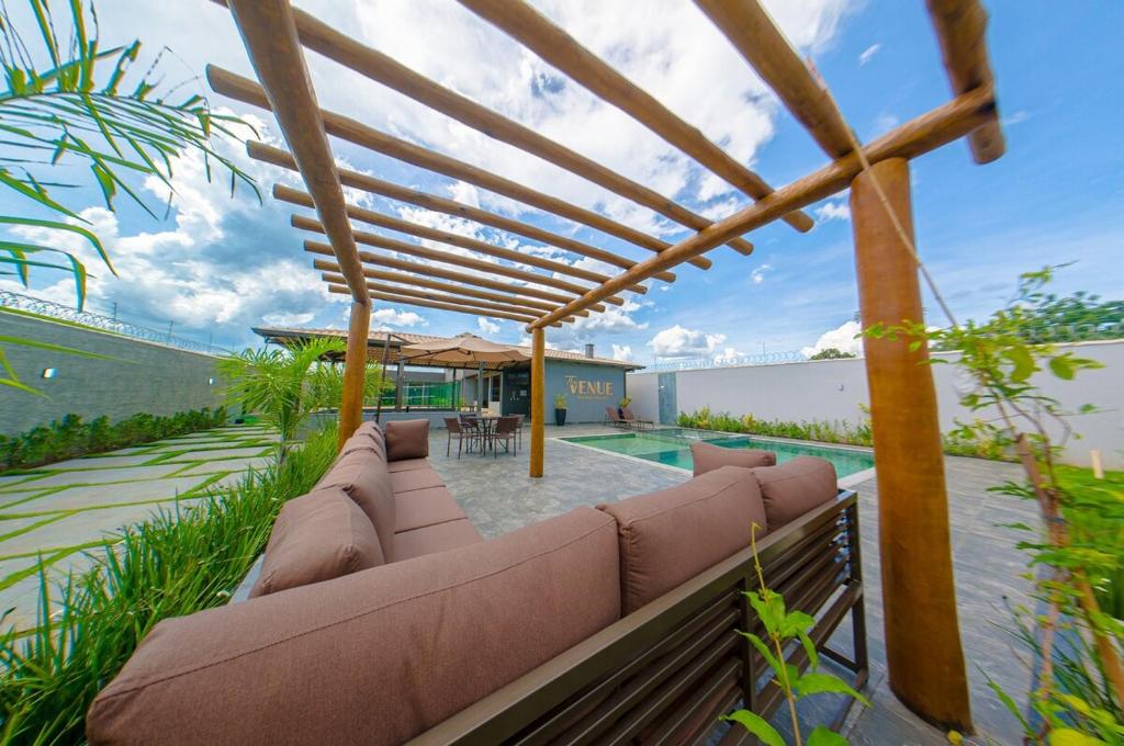 an outdoor patio with a couch and a pool at Espaço premium, Casa com 5 quartos, piscina aquecida & Jacuzzi in Caldas Novas