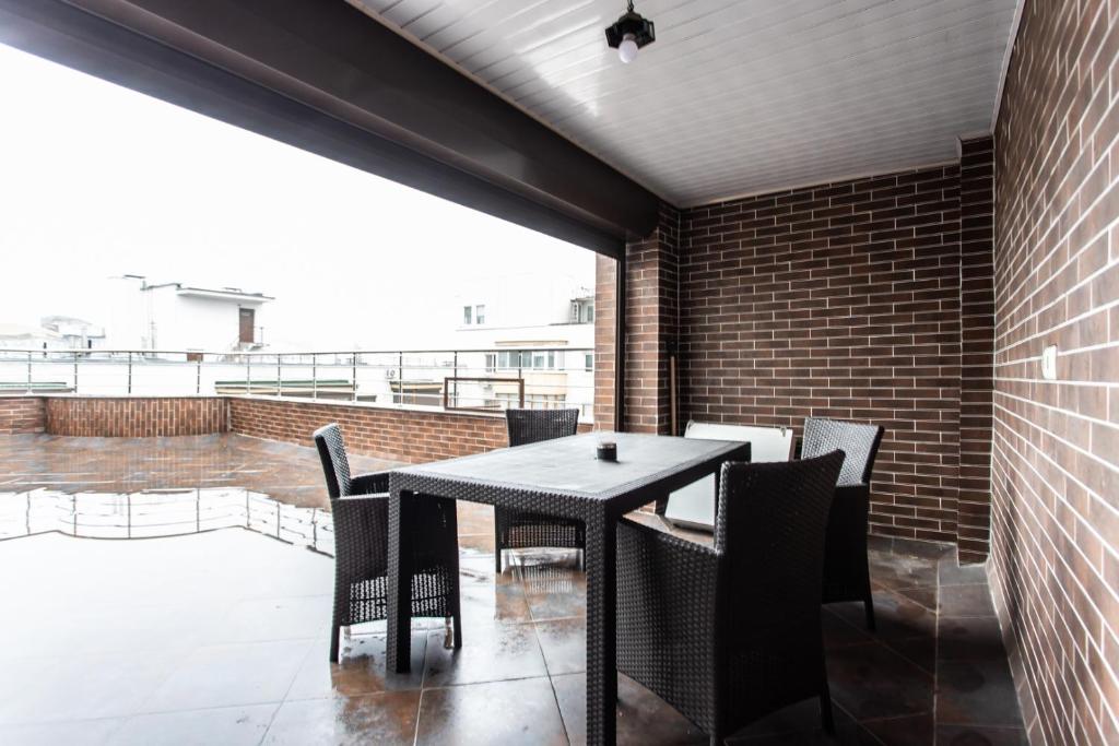 a black table and chairs on a balcony at Spacious apartment with terrace in Chişinău