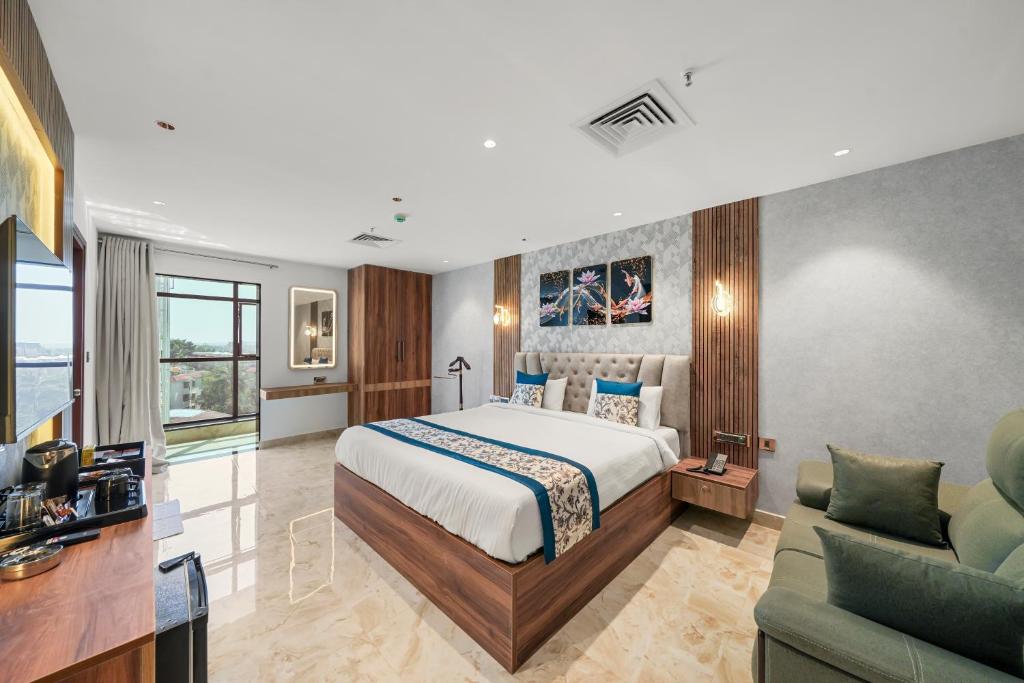 a bedroom with a bed and a living room at Hotel Grand Kasturi in Bengaluru