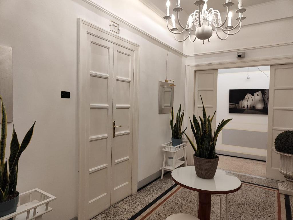 a hallway with a door and a table and plants at Room and Suite - BARI CENTRALE - in Bari