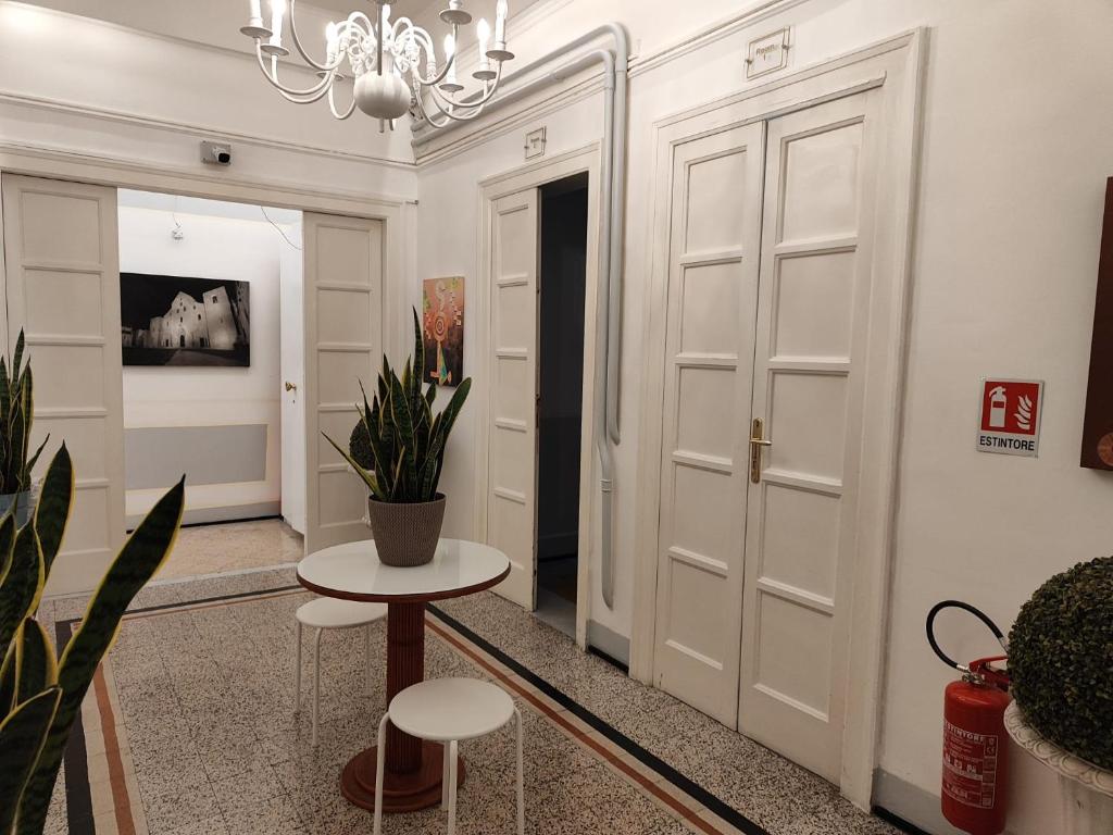 a hallway with white doors and a table and stools at Room and Suite - BARI CENTRALE - in Bari