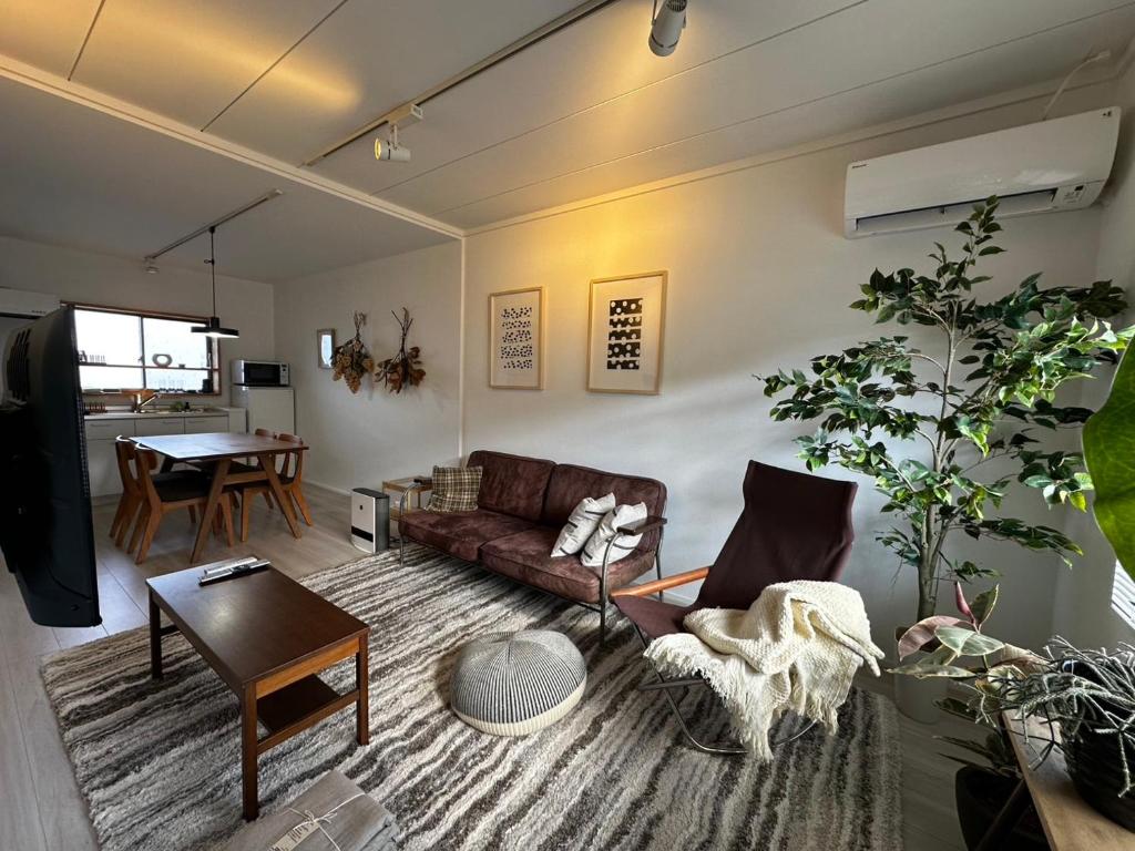 una sala de estar con un sofá y una mesa en 伊勢志摩観光に最適 パールロードの玄関口 PAARU inn 2階B室 セルフチェックイン, en Toba