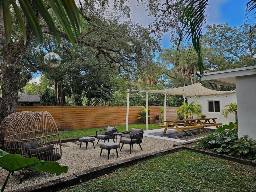 a backyard with a picnic table and chairs and a swing at -Disco Bungalow- One third mile to FTL Marine Center in Fort Lauderdale