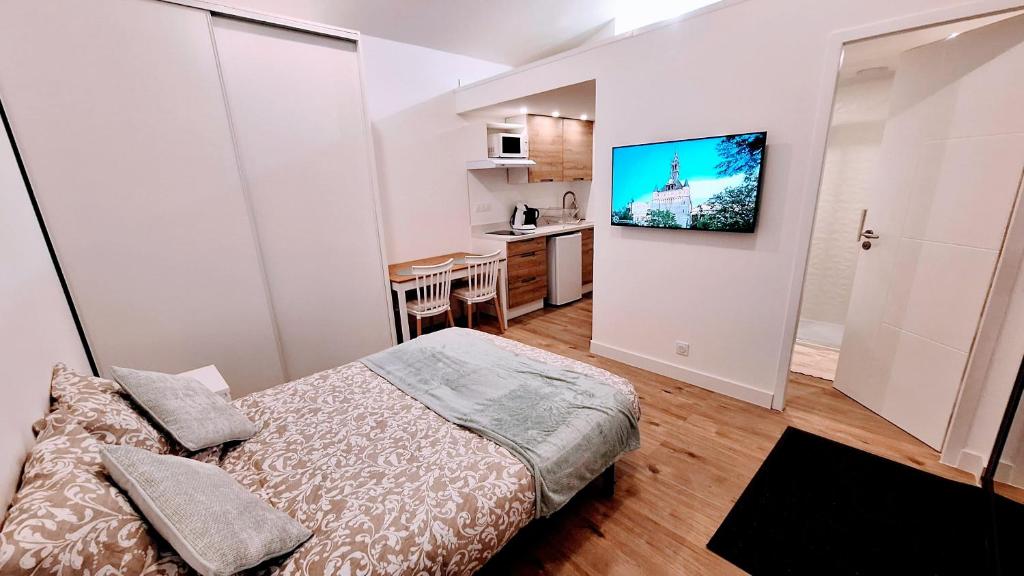 une petite chambre avec un lit et une cuisine dans l'établissement L'extension - Studio indépendant - Secteur Meet, à Aussonne