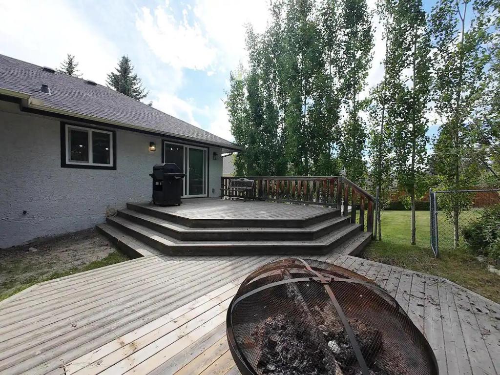 a deck with stairs and a trash can in front of a house at The Luxe Escape Calgary I 3BR Vacation Home in Calgary
