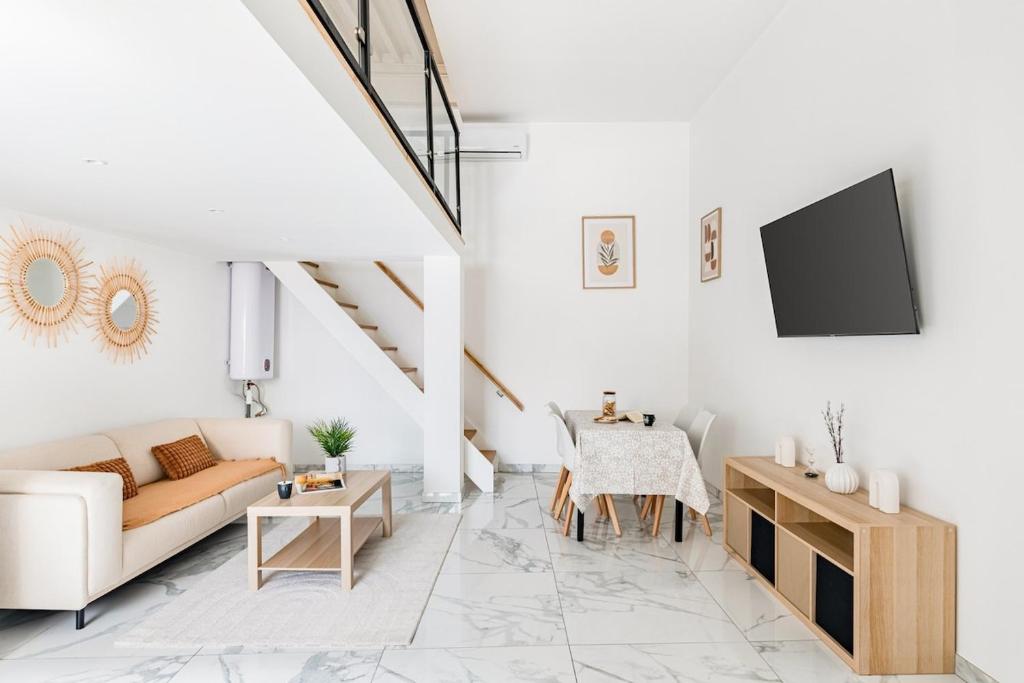 a white living room with a couch and a table at xx Le Frappa xx Loft & Spa City in Saint-Étienne