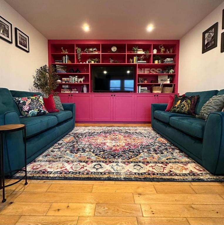 a living room with two couches and a tv at Ness in the City in Inverness