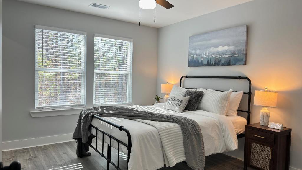 una camera da letto con un letto e due finestre di Modern new townhouse near Stone Mountain Sleeps 10 a Snellville