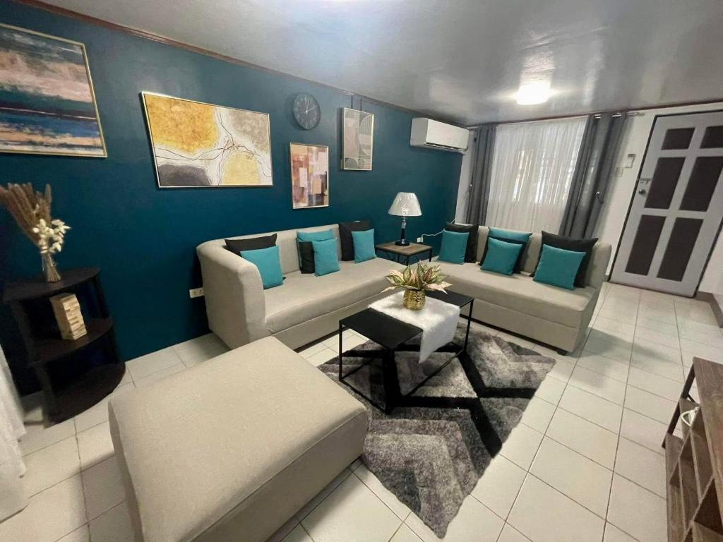 a living room with a couch and blue walls at Goras Haven in Iba