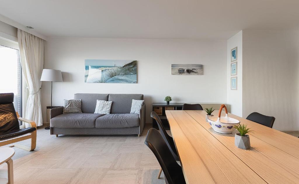 a living room with a table and a couch at Cadiz 0602 in Sint-Idesbald