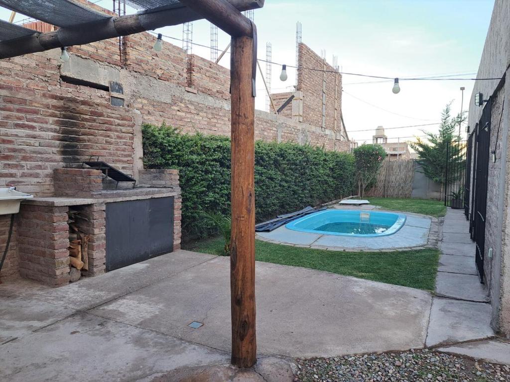 a wooden pole in a backyard with a swimming pool at Escapada perfecta con pileta privada- 2 personas in Ciudad Lujan de Cuyo