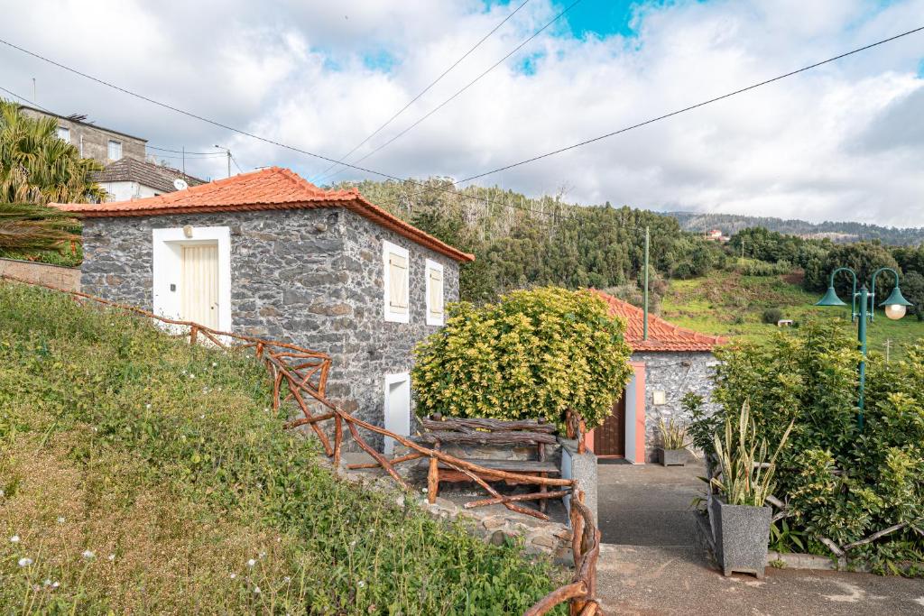 a stone house with a staircase leading up to it at Vila Pitaias in Estreito da Calheta