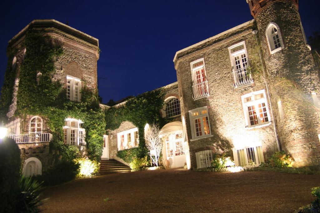 a large stone building with ivy on it at night at Domaine Saint Clair - Le Donjon in Étretat