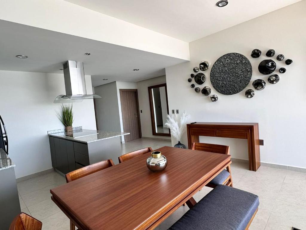a kitchen and dining room with a wooden table at Altomare Depa 1804 in Mazatlán