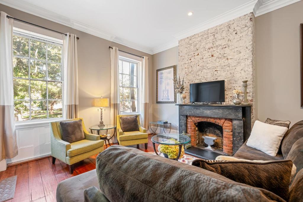 a living room with a couch and a fireplace at No Car Needed King Bed Balcony Abercorn And York-2 in Savannah