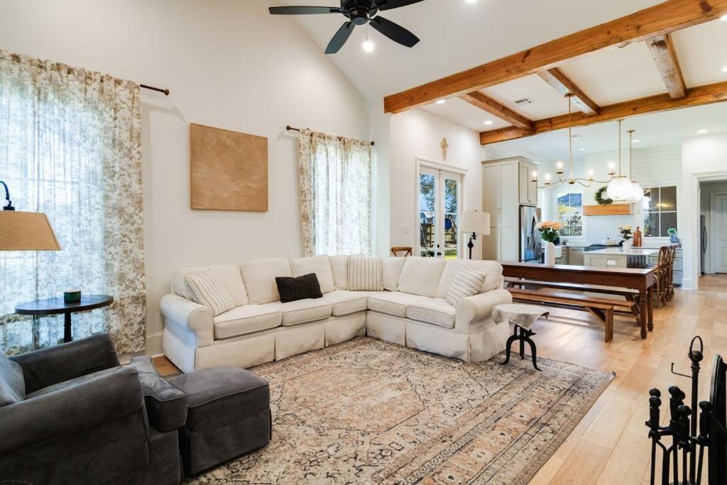 ein Wohnzimmer mit einem weißen Sofa und einem Klavier in der Unterkunft Cajun Country Retreat King Beds Patio Arcade Luxe in Lafayette