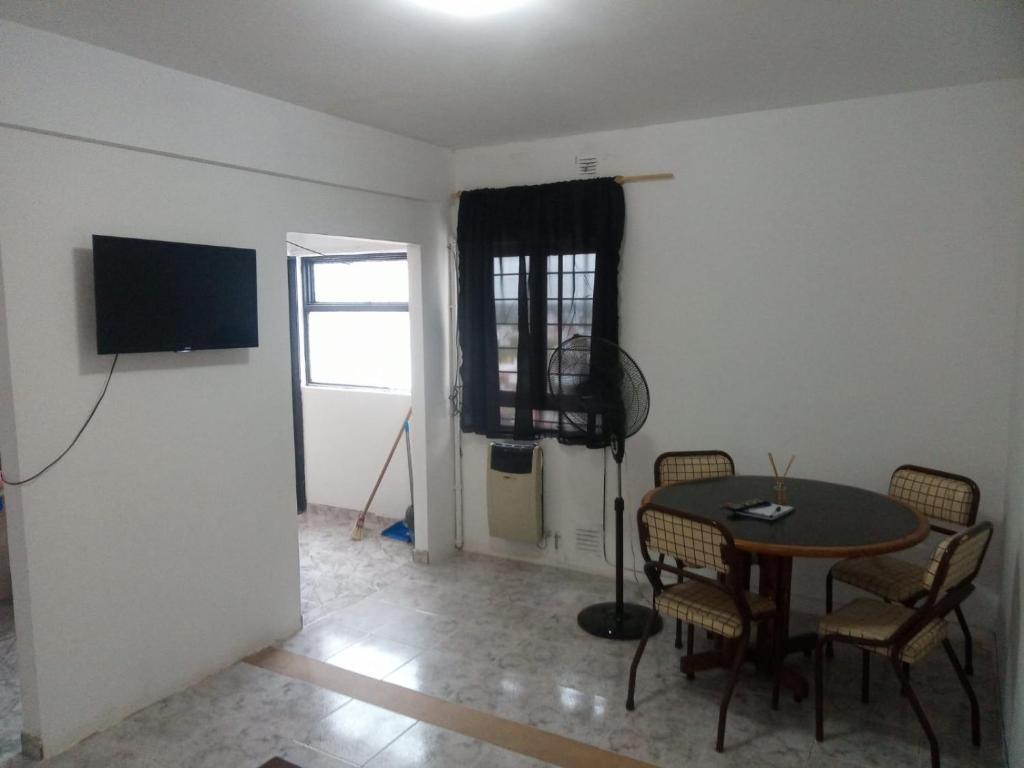 a dining room with a table and chairs and a television at Departamento céntrico in Concepción del Uruguay