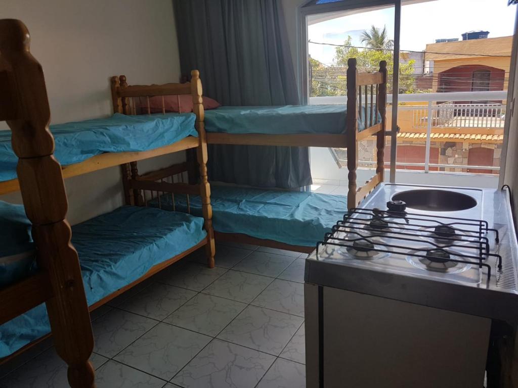 卡波布里奥RoseMarAzul Temporadas的客房设有两张双层床和炉灶。