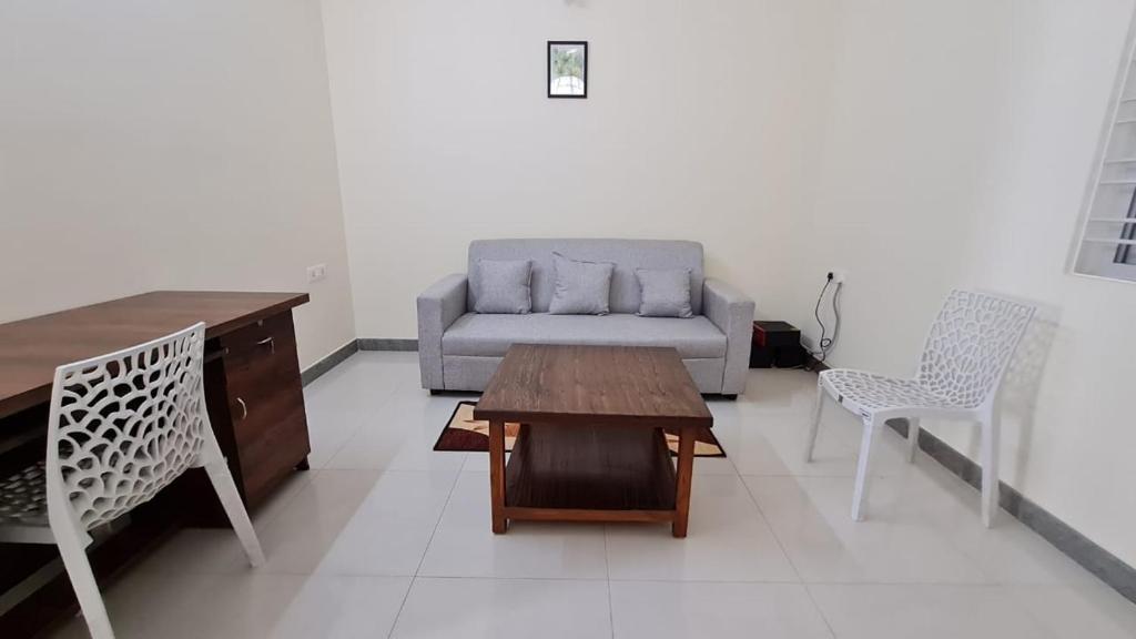 a living room with a couch and a table and chairs at HSR layout Abode 2 in Bangalore