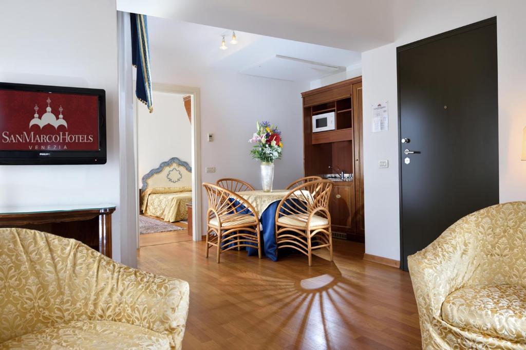 a living room with a table and chairs at Royal San Marco Hotel in Venice