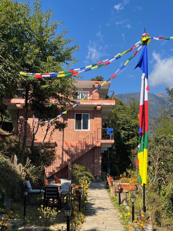 a house with flags on a sidewalk next to a building at Les Terrasses Himalayan Resort in Charikot