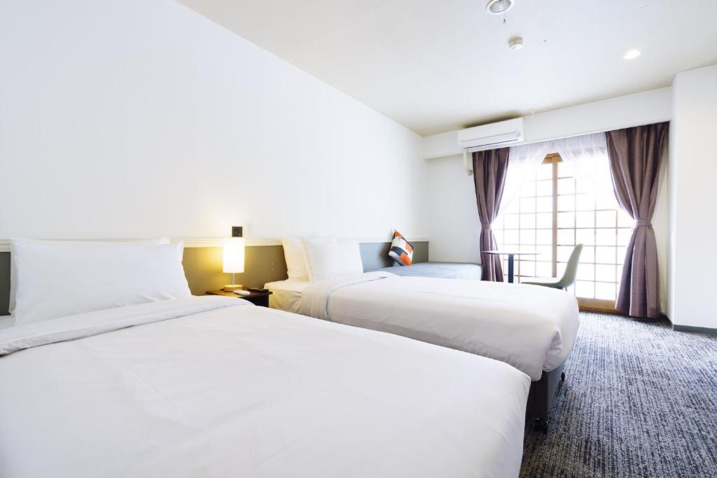 Postel nebo postele na pokoji v ubytování Hakuba Gateway Hotel