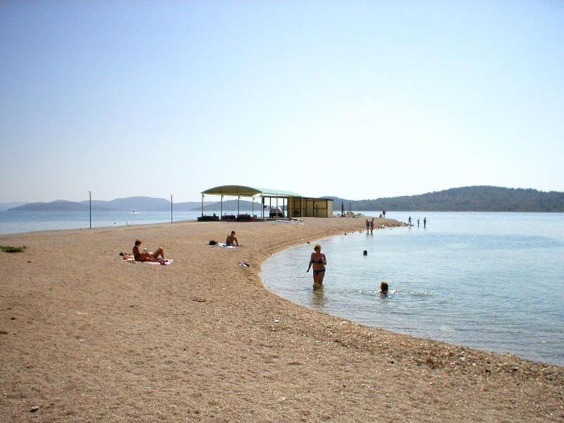 a group of people on a beach near the water at Apartments Sun & Sea in Vodice