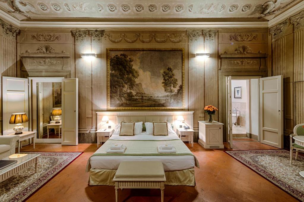 1 dormitorio con 1 cama y una pintura en la pared en Palazzo Guicciardini, en Florencia