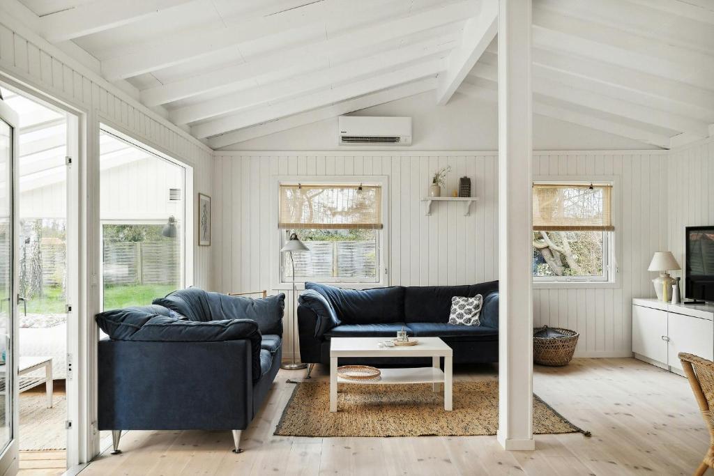 a living room with two blue couches and a table at Bright And Cozy Cottage Close To The Sea in Hornbæk