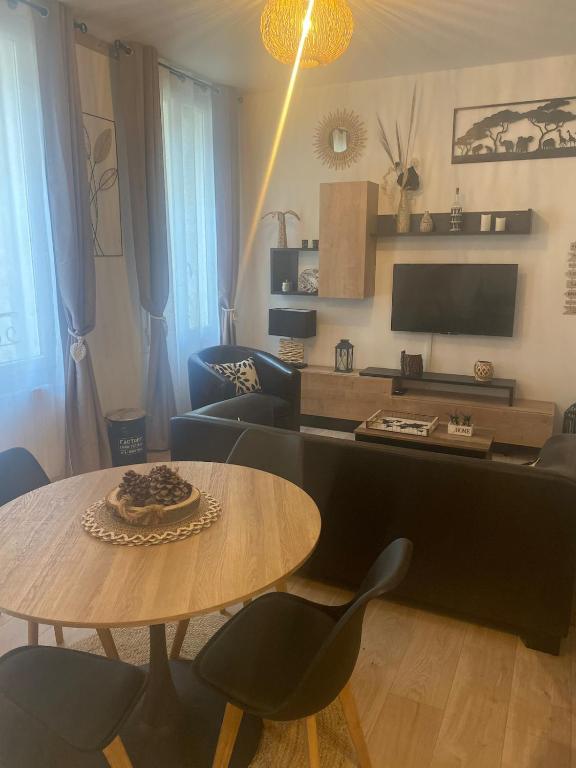 un salon avec une table et quelques chaises dans l'établissement Appartement près de la Citadelle, à Blaye