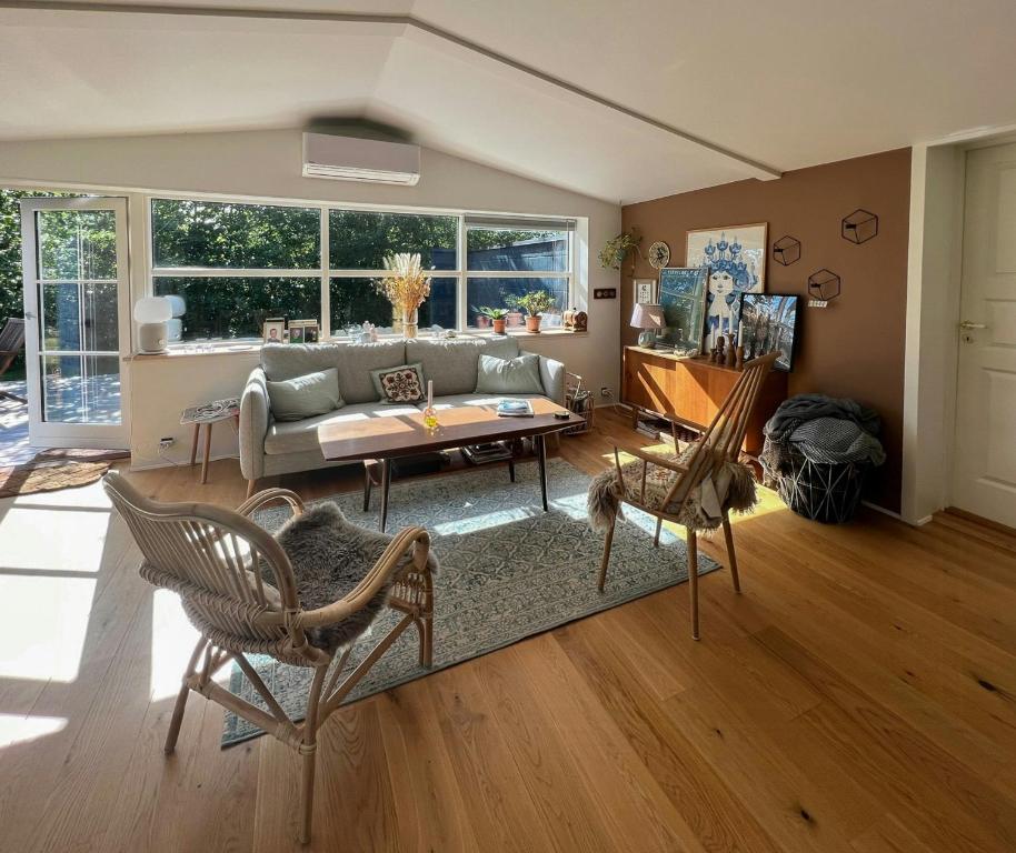 una sala de estar con un sofá y una mesa en Home For Family In Tisvilde, en Tisvildeleje