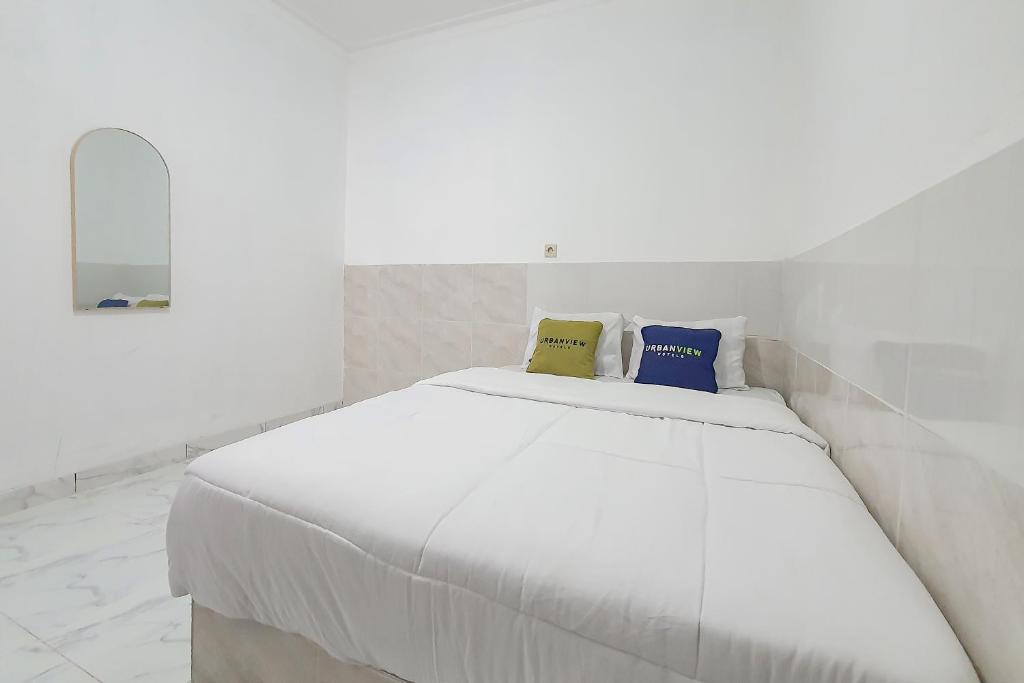 a white bed with two pillows on top of it at Urbanview Aurel House Cirebon in Plered
