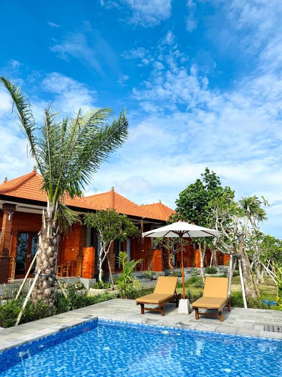 a resort with a swimming pool and two chairs and an umbrella at South Hill Pandawa in Nusa Dua