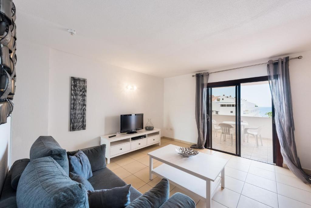 a living room with a couch and a table at Paloma Beach Apartments in Los Cristianos