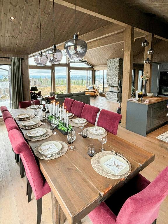 a wooden table with pink chairs and a dining room at Architect Mountain Cabin At Lygna With Views in Jaren