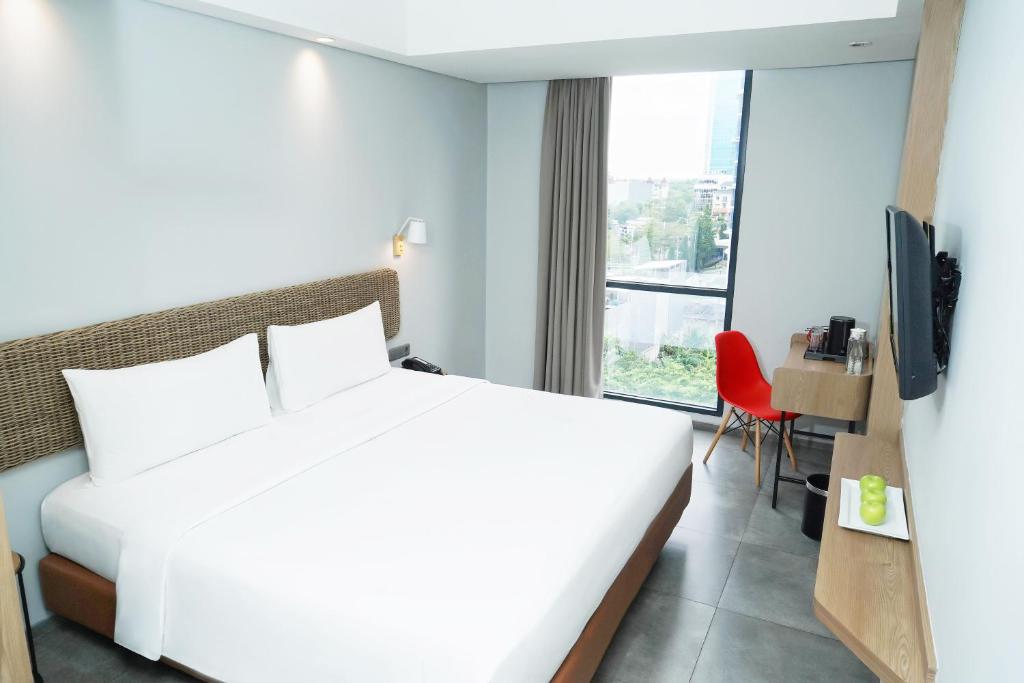 Postel nebo postele na pokoji v ubytování Neo Hotel Puri Indah