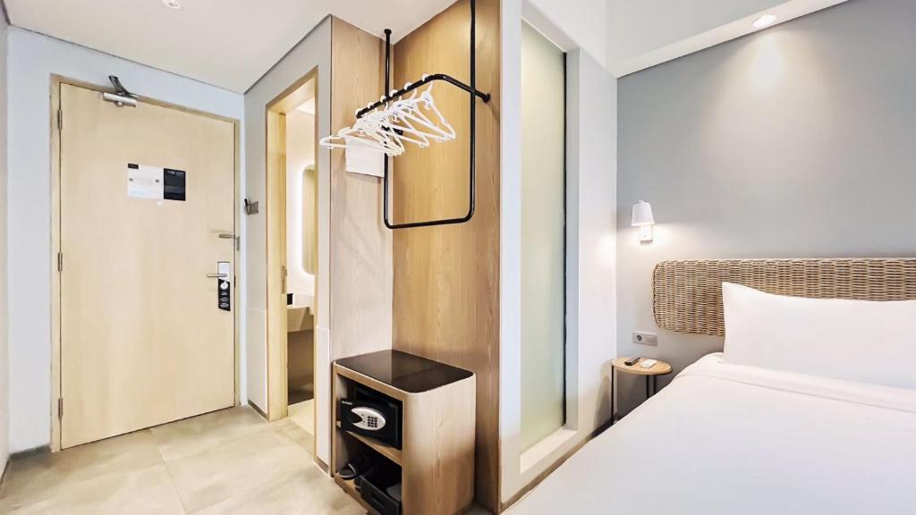 Postel nebo postele na pokoji v ubytování Neo Hotel Puri Indah