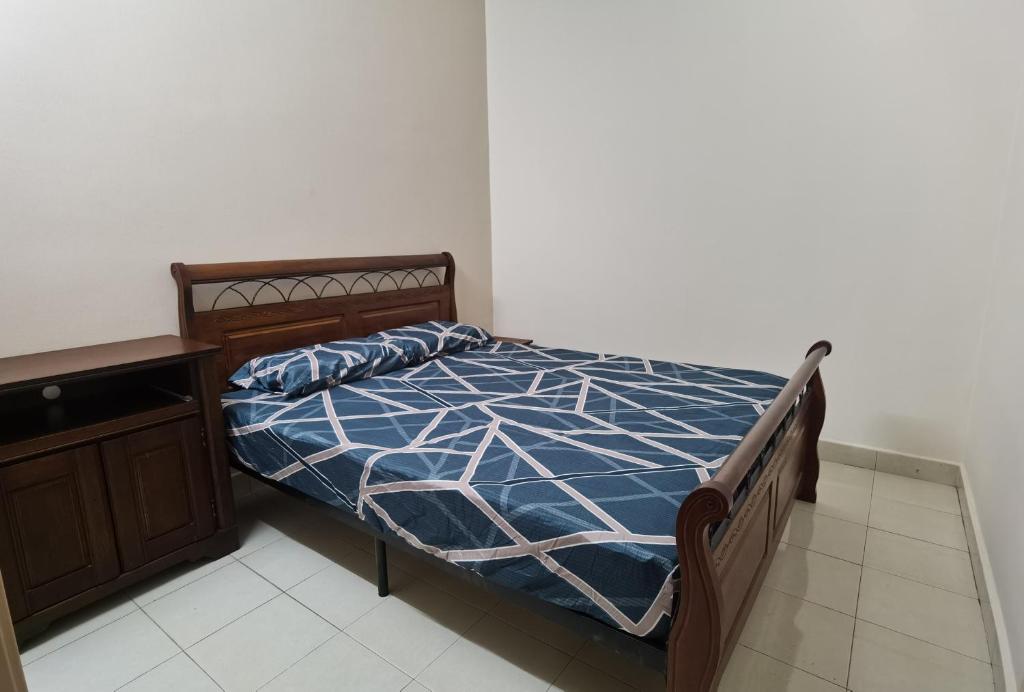 a bedroom with a bed with a blue and white comforter at 4 Bedrooms 4 Bathrooms 10Pax Comfy Sleeps Landed Spacious House in Seri Kembangan